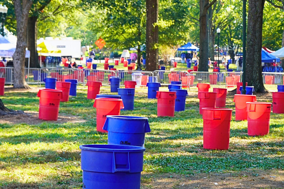 Red and blue trash cans set out along a path in The Grove on a Friday morning